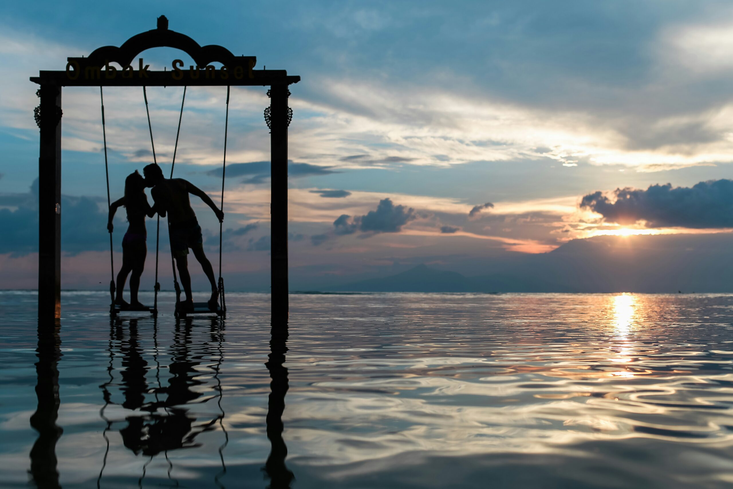 Partners Kissing on Swing in Ocean